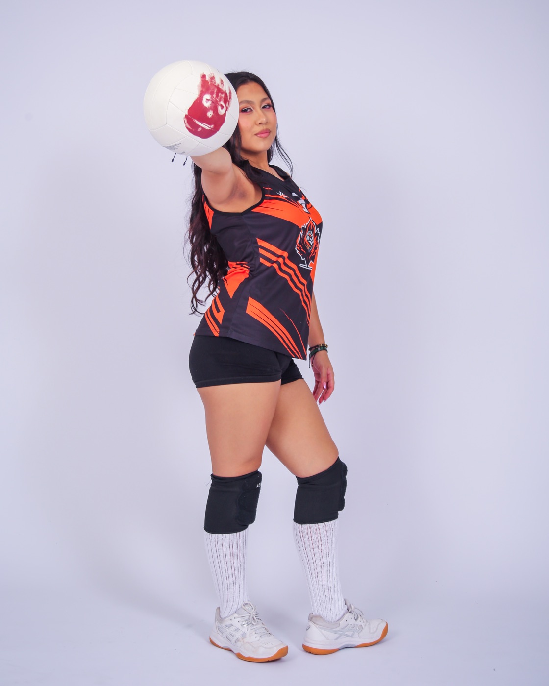 Isabella con su uniforme negro y naranja de voleibol